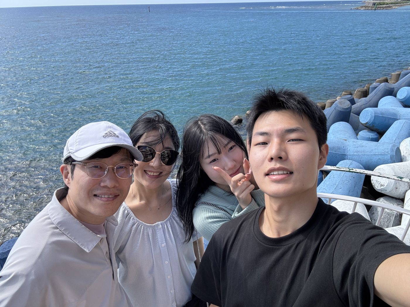 바다 방파제 앞에서 찍은 가족 네 명 셀카