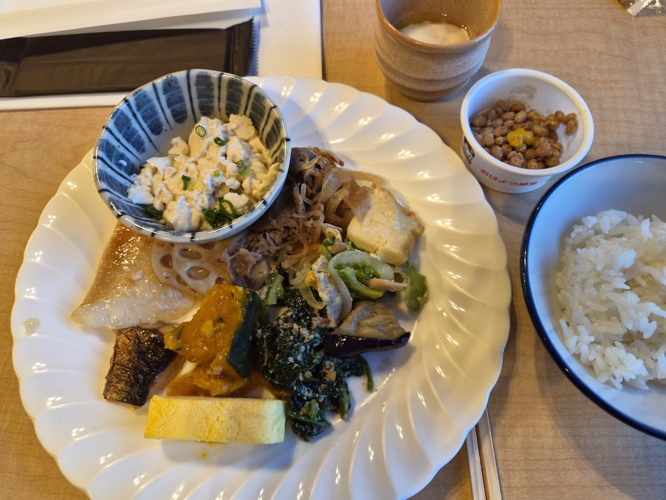 생선구이, 연근, 단호박, 시금치무침, 계란말이를 담은 조식 접시와 낫토, 밥