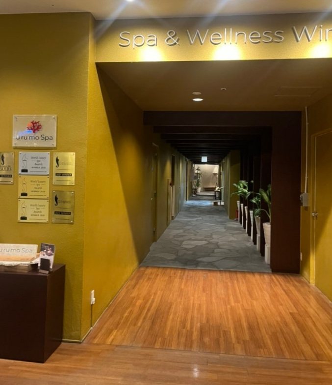 Spa & Wellness 간판 아래 돌바닥 복도가 길게 이어진 스파 입구